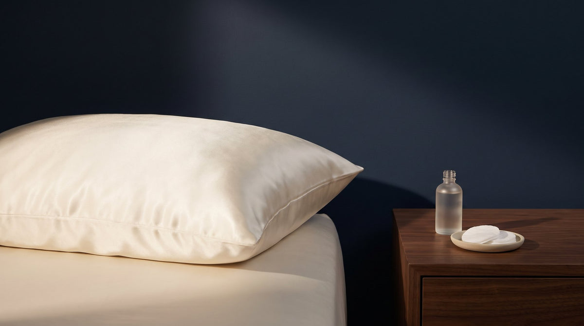 A white mulberry silk pillowcase on a neatly made bed in soft morning light