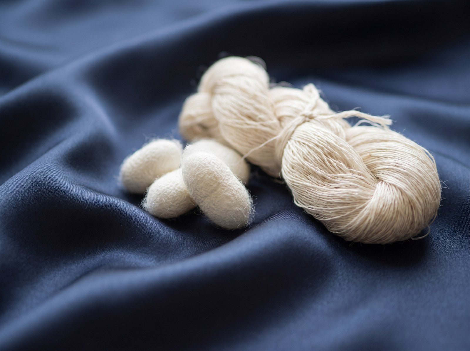 Mulberry silk cocoons and raw silk thread on navy KINT silk fabric