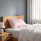 Pillow in the fitted KINT silk cover on a bed in a calm bedroom