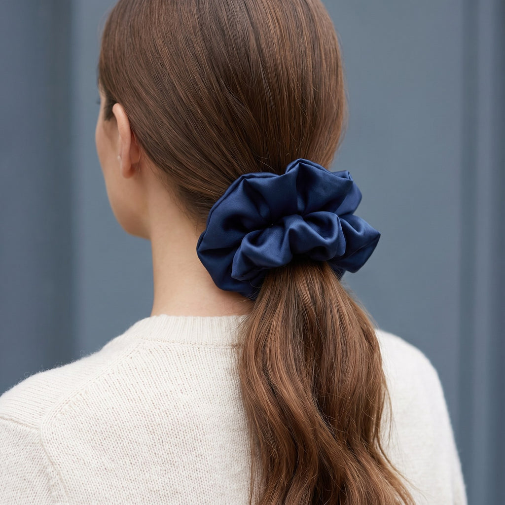 A low ponytail tied with the large navy KINT silk scrunchie