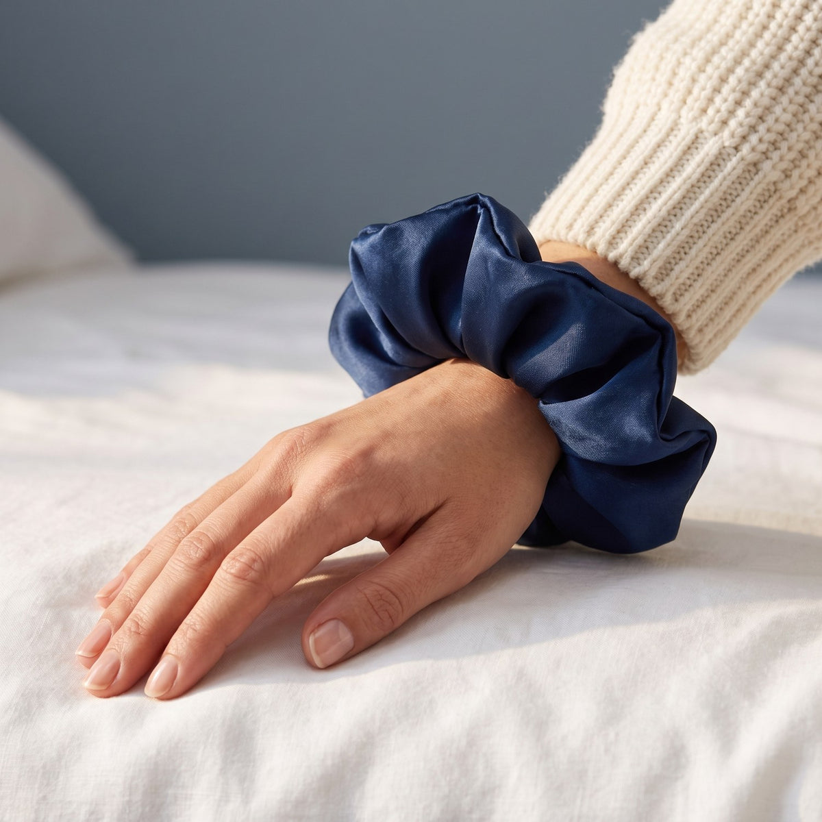 The large navy KINT silk scrunchie worn on a wrist