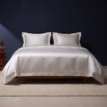 KINT 19 momme mulberry silk four-piece bedding set in Pearl Silver on a bed in a calm bedroom