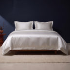 KINT 19 momme mulberry silk four-piece bedding set in Pearl Silver on a bed in a calm bedroom