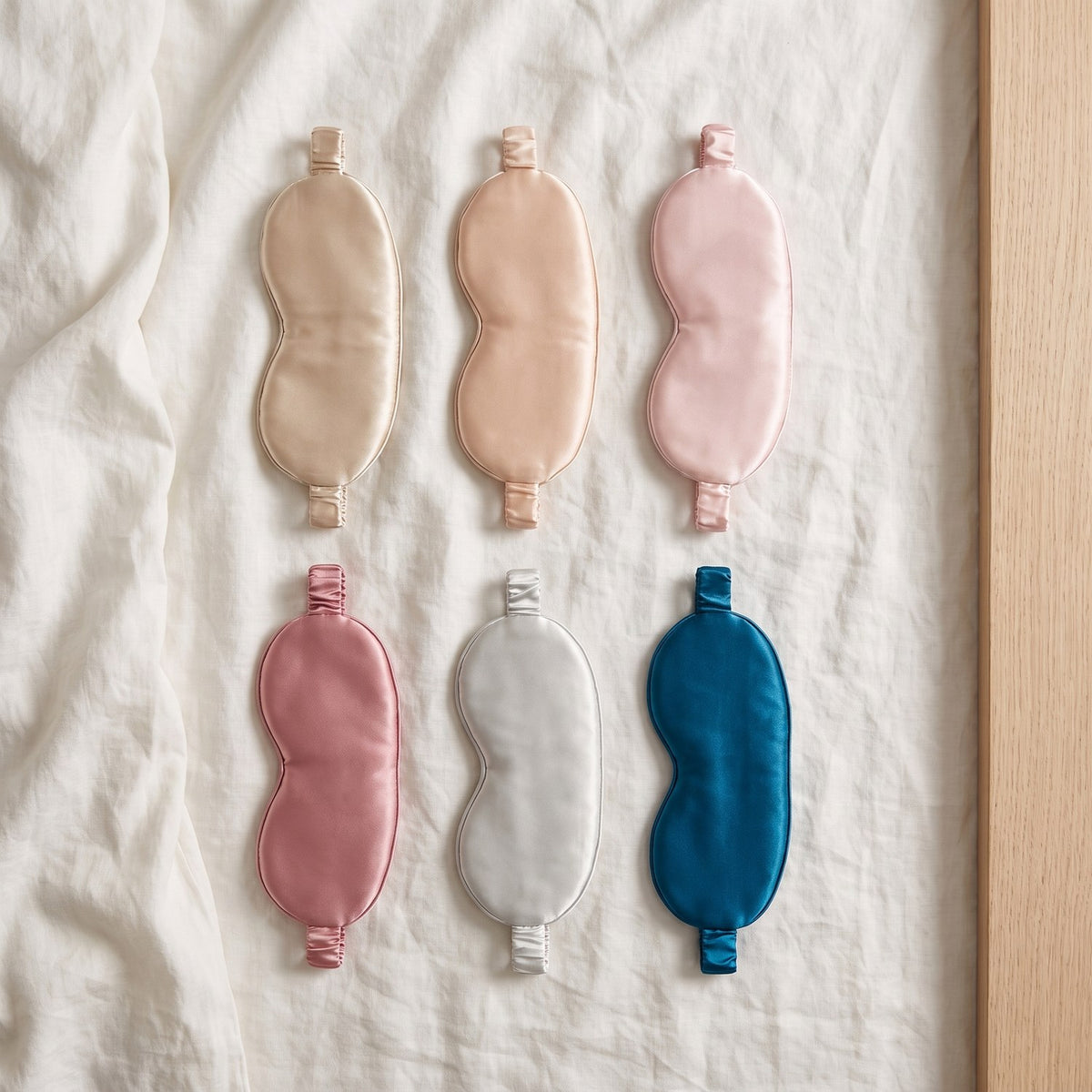 KINT 3D mulberry silk sleep mask in six colors laid on white linen