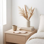 KINT silk sleep mask on a pale oak bedside table in a Scandinavian bedroom