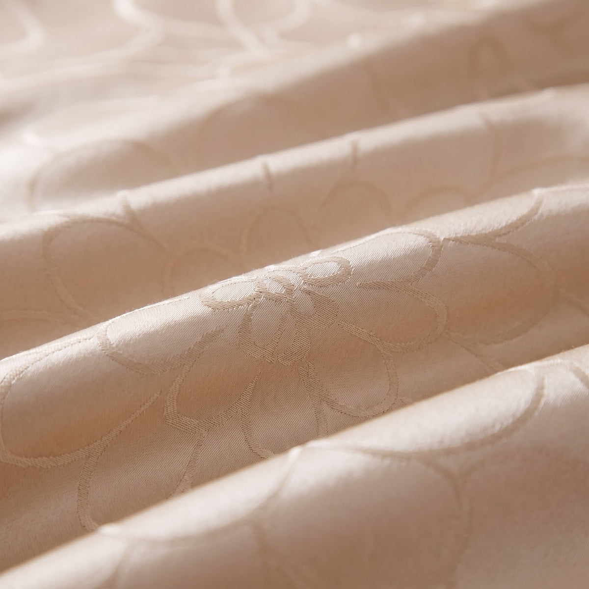 Close-up of the champagne jacquard weave with its woven flower-petal pattern and satin sheen