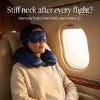 Woman asleep in an airplane window seat with the navy KINT silk neck pillow and sleep mask